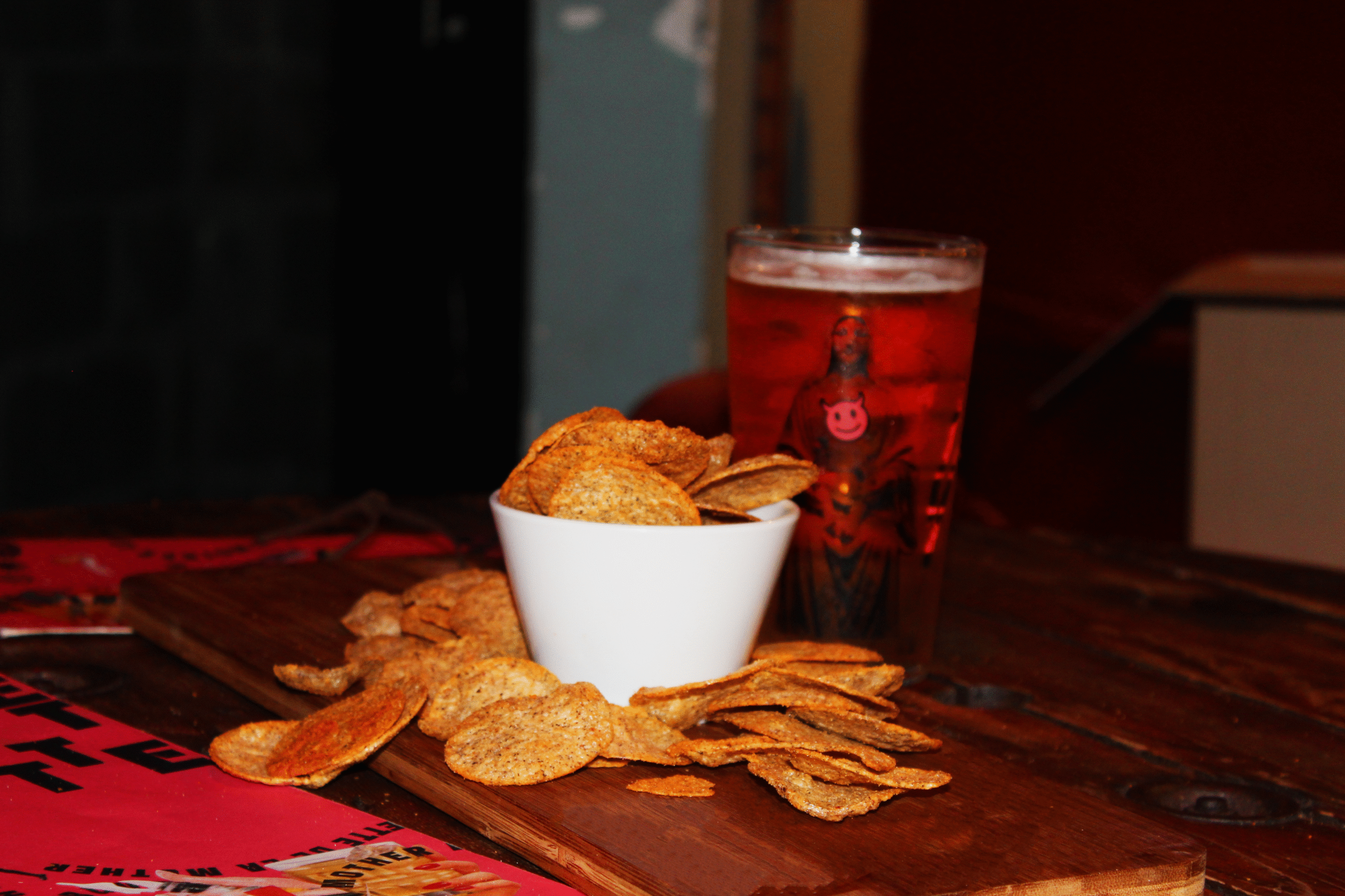 Bol de chips croustillantes accompagné d’un verre de bière ambrée sur une table en bois, ambiance apéritif convivial.